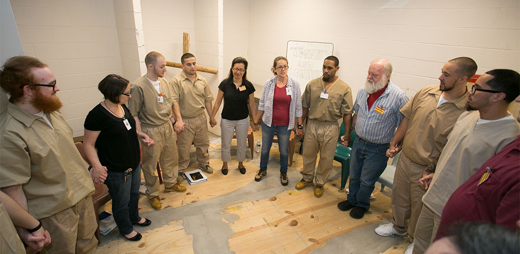 PTSEM students praying with prisoners