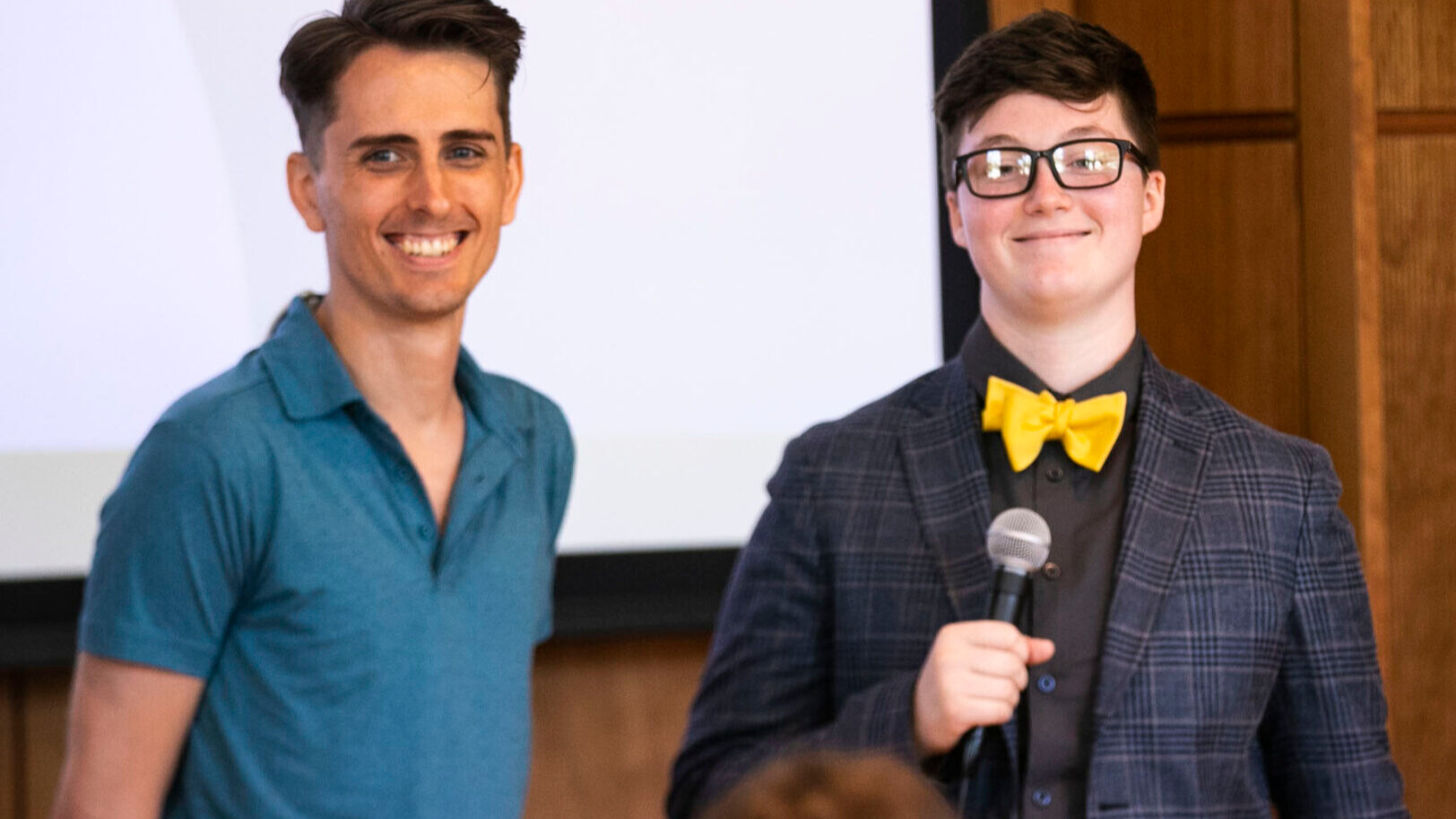 Two male students hosting an event.