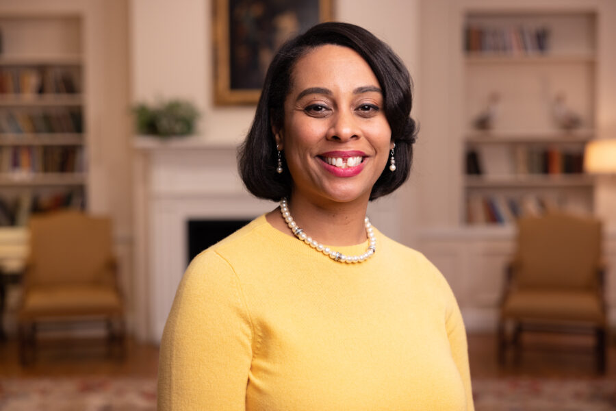 Dr. Keri Day poses for a professional photo in a yellow sweater.