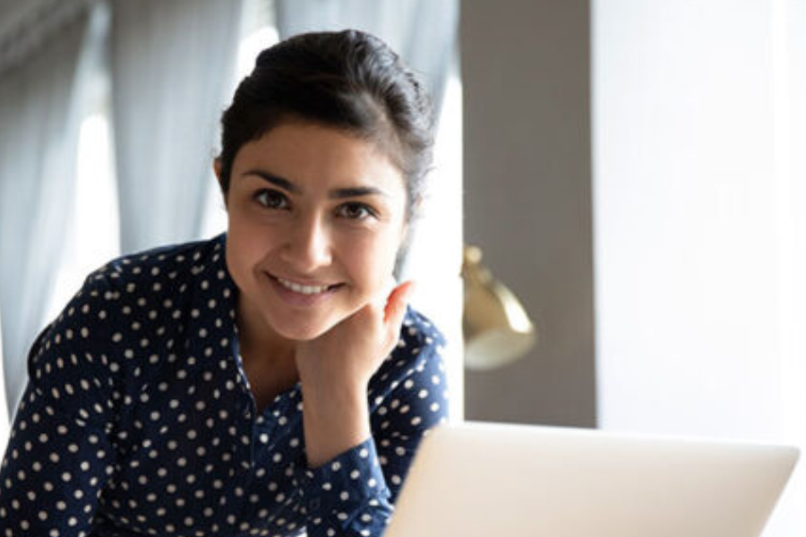 Princeton Theological Seminary female student smiling behind a laptop