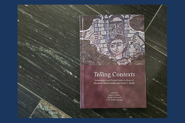 photograph of the book "Telling Contexts : archaeological and textual studies in honor of Elizabeth Bloch-Smith and Mark S. Smith" edited by Julie B. Deluty, Heath D. Dewrell and F.W. Dobbs-Allsopp with some dark grey marble flooring as the background