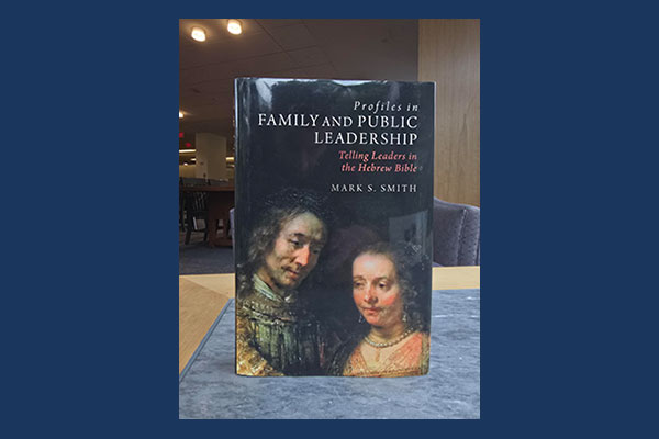 A book, Profiles in family and public leadership : telling leaders in the Hebrew Bible by Mark S. Smith, with an excerpt of the Rembrandt painting, The Jewish Bride (1665-1669) on the cover on top of a table in Wright Library