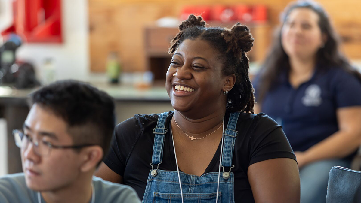 Student sitting at desk smiling